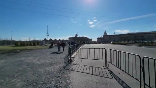 The fenced walkway from the parking area toward the complex