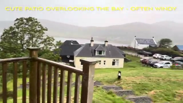The pod’s patio with wooden railing overlooking Uig and the bay