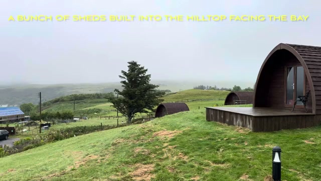 Arched glamping pods set into the grassy hilltop above Uig, facing the bay