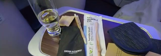 Pre-departure drink and amenity kit contents on the tray table