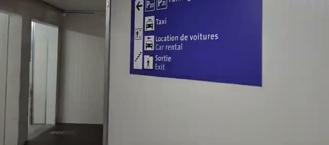 Sign pointing to car rental in the covered walkway