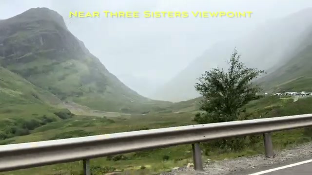 The Three Sisters viewpoint in Glencoe, misty with a roadside guardrail