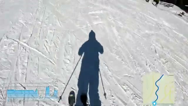 Skier’s shadow on the groomed piste, descending in sunshine