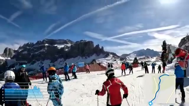 The busy summit at the top of Gran Paradiso, skiers ready to drop in under a rocky peak