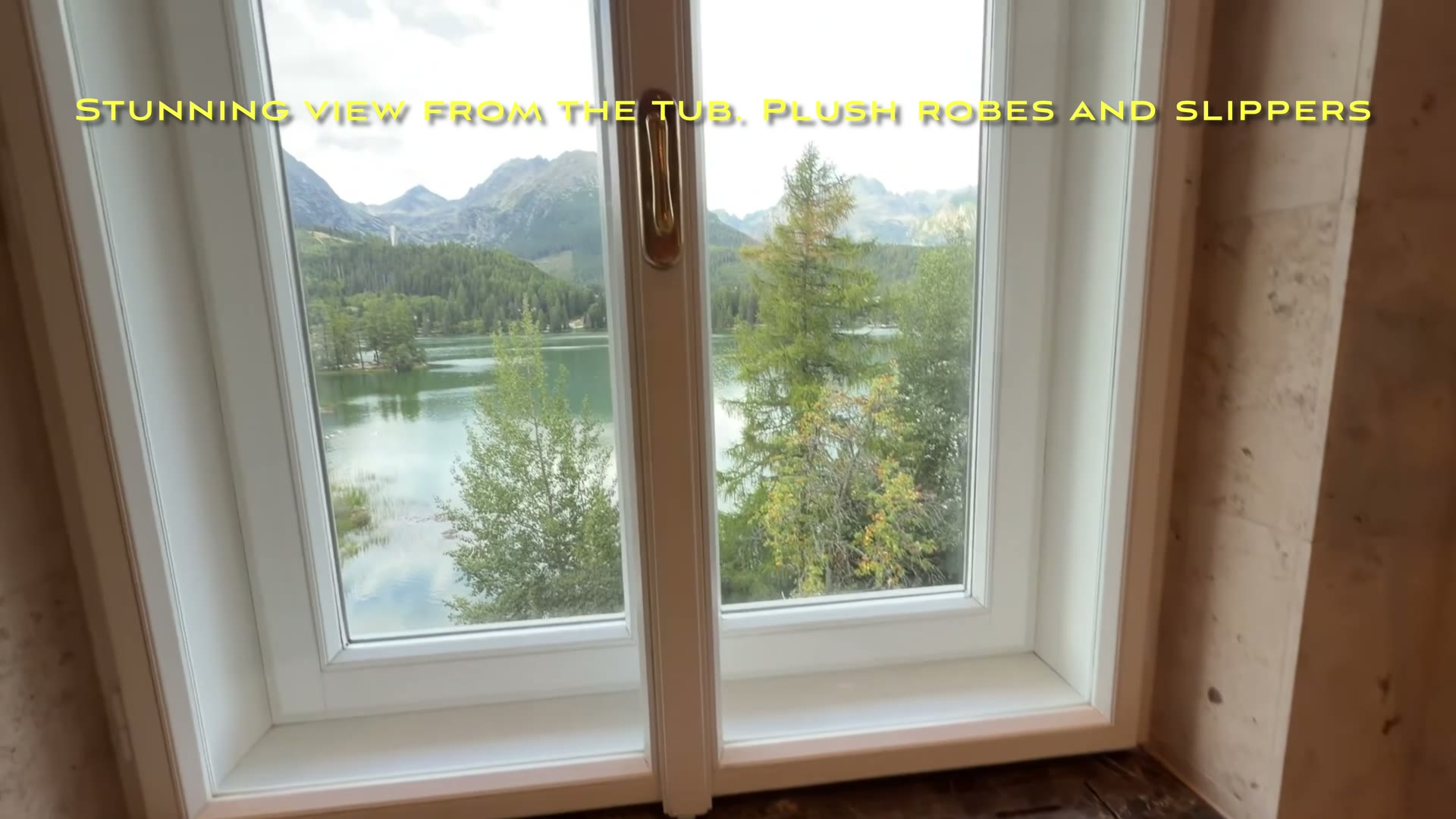 Lake and mountain view through the bathroom window beside the tub