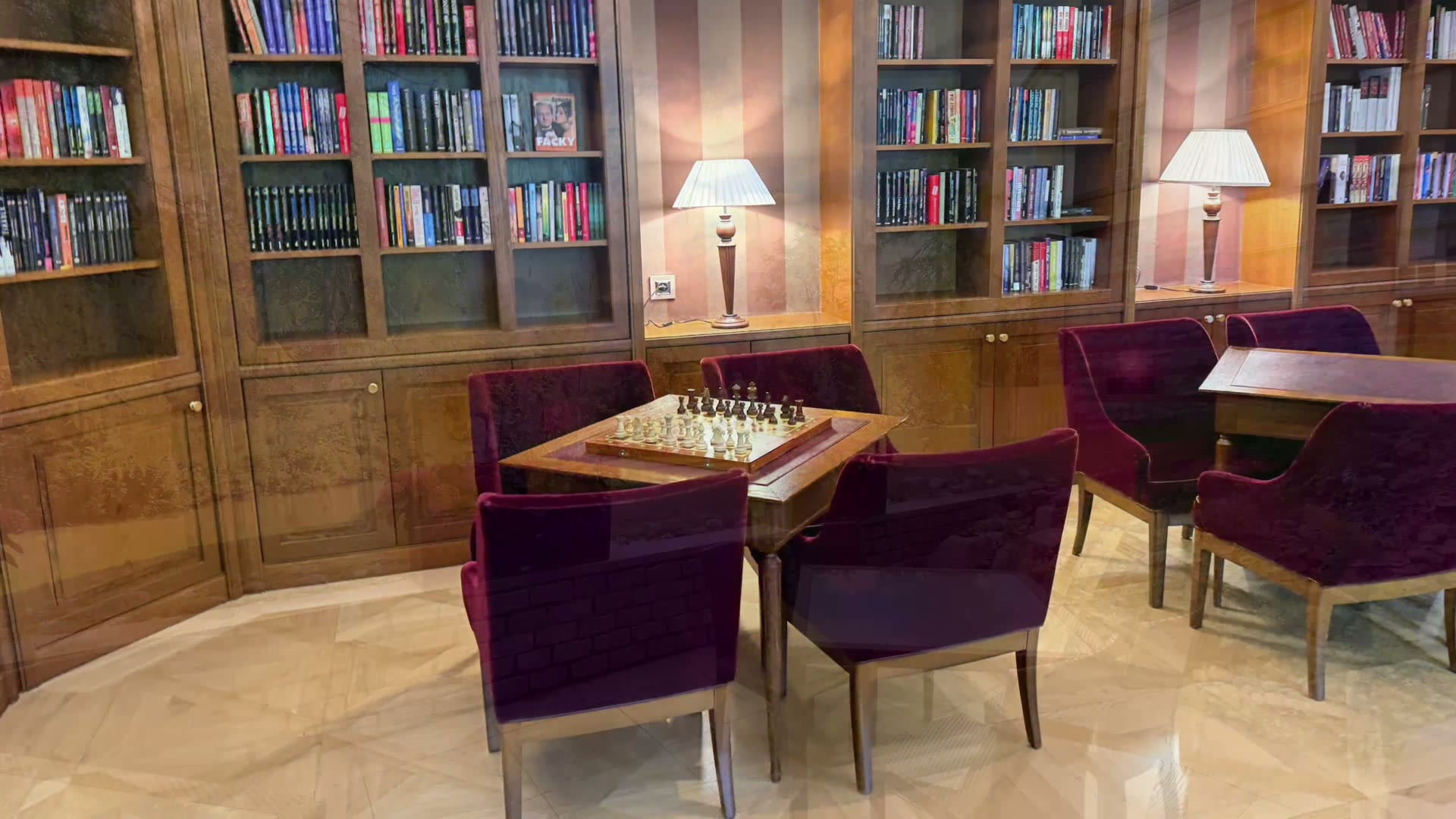 Chessboard and purple armchairs in the hotel’s wood-paneled library and games area