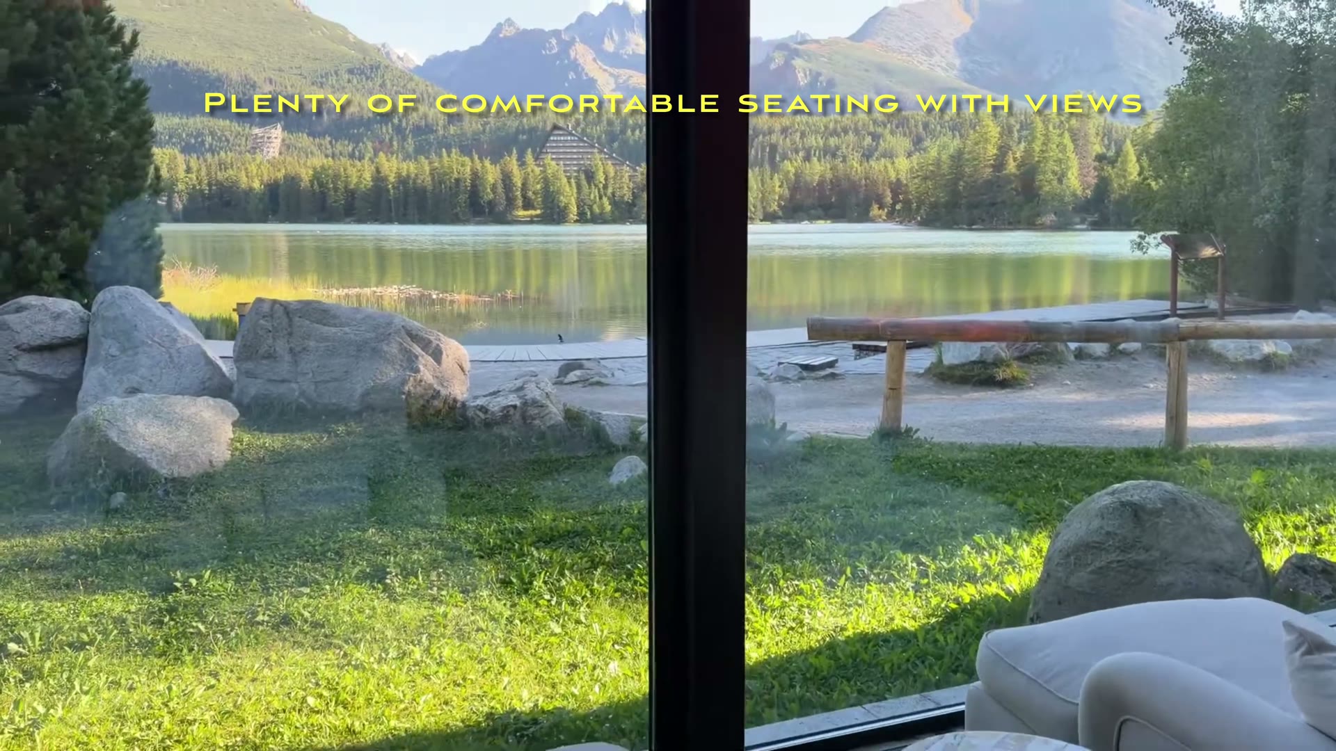 Spa lounge seating beside a window overlooking the lakeshore, trees and mountains