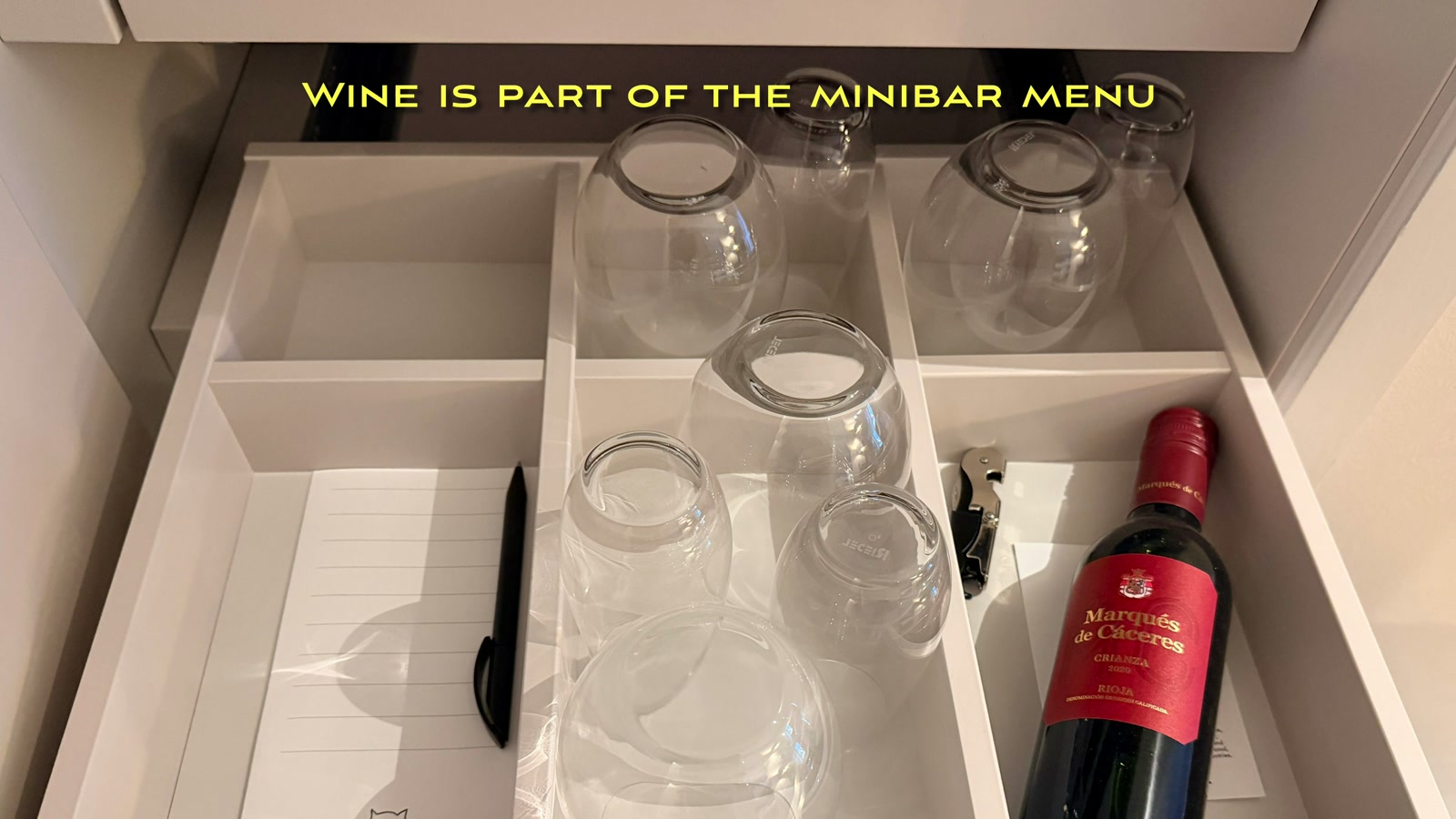 Wine glasses and a bottle of Rioja tucked into the minibar drawer