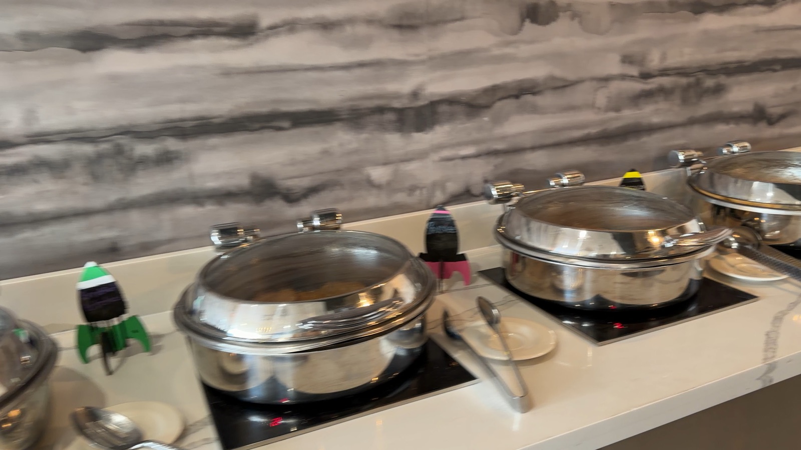 Breakfast buffet chafing dishes decorated with small rocket toppers, a fun detail matching the hotel’s location