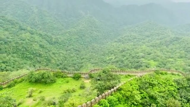 The fort wall winding through jungle-clad hills