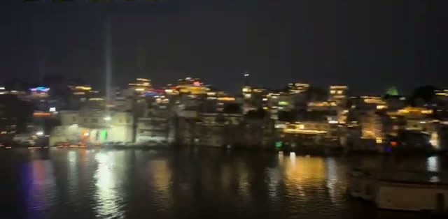 The Lal Ghat waterfront lit up at night, reflected in Lake Pichola