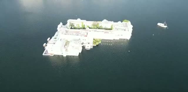 The Taj Lake Palace floating on Lake Pichola with a boat nearby
