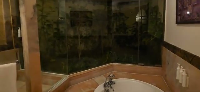 The massive bathroom with its “forest” feel around the tub