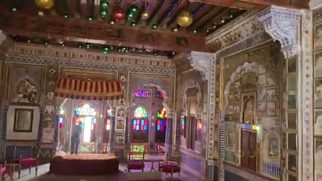 Ornate palace hall with stained-glass windows