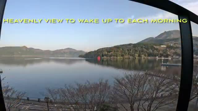Lake Ashi at dawn from the apartment — the red torii gate of Hakone Shrine in the distance