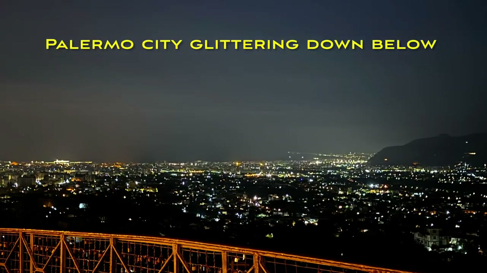 Palermo city lit up at night, seen from a hilltop restaurant