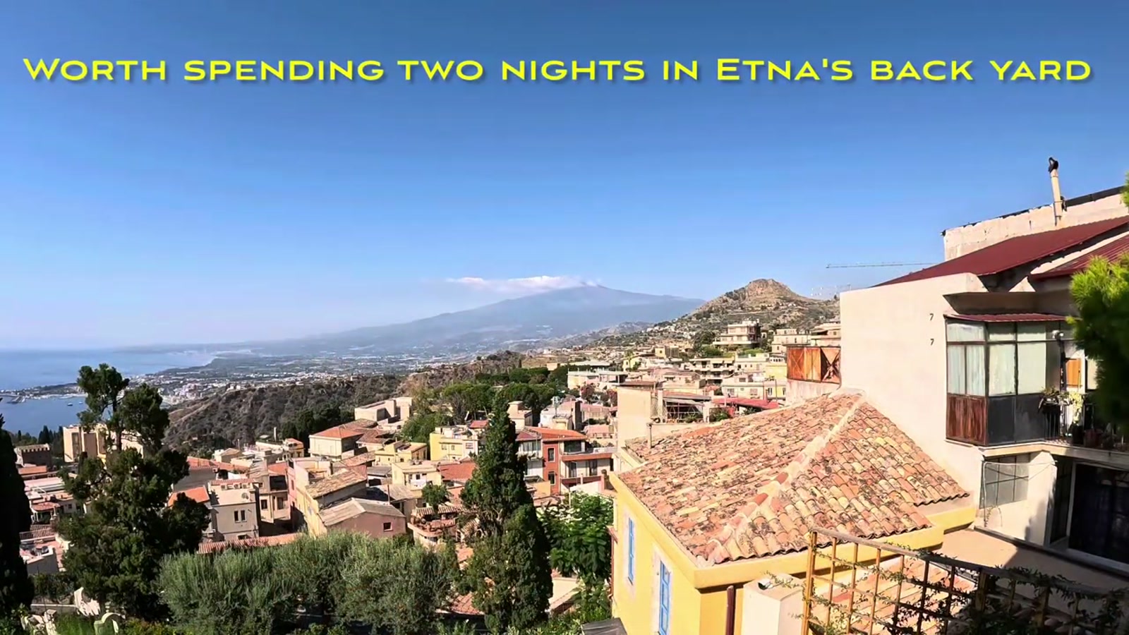 Taormina’s rooftops with Mount Etna visible across the bay