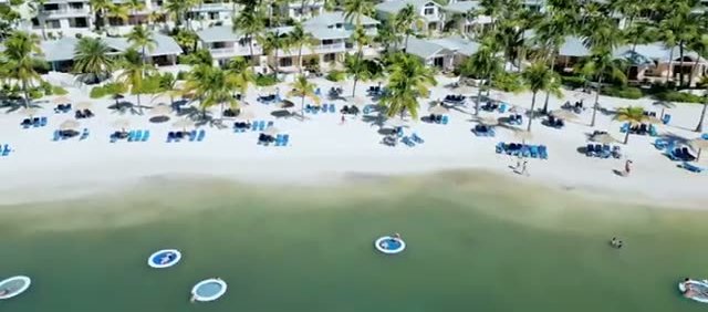 Aerial view of Mamora Bay’s calm white sand beach