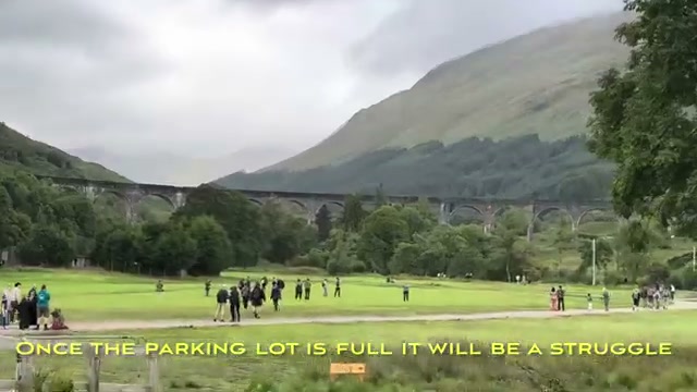 Spectators gathered on the meadow facing the viaduct